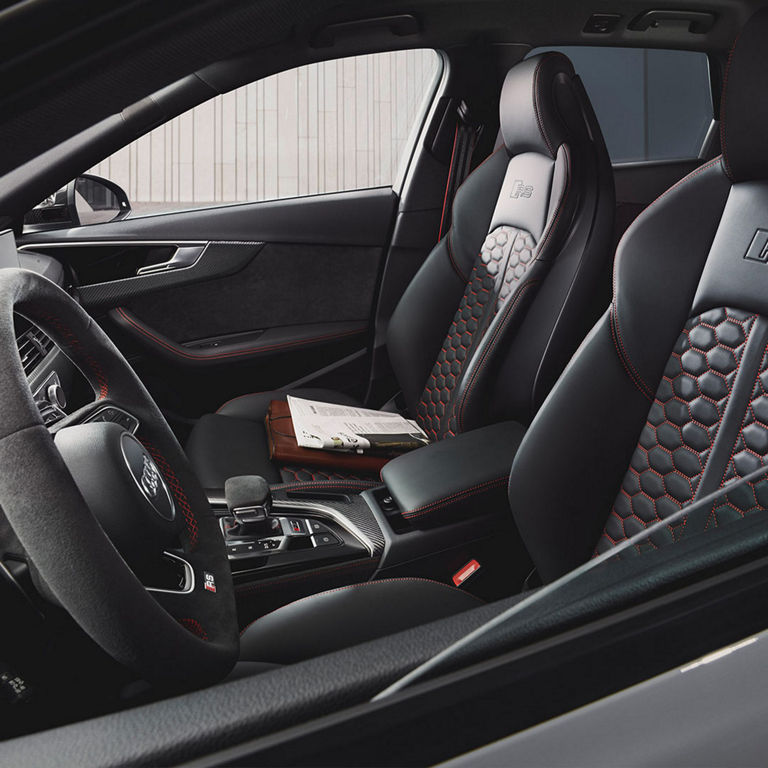 Car interior with leather seats featuring red stitching and prominent RS branding.