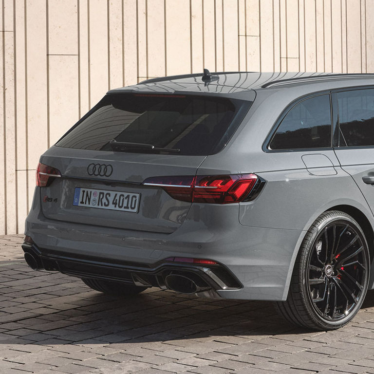 Audi RS 4 Avant parked near a building with clear taillights and black rims.