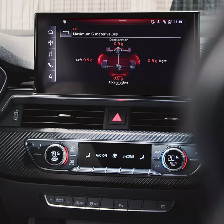 Car's interior focusing on the infotainment system displaying G-force meter and climate control settings.