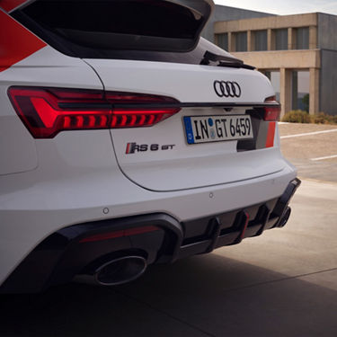 Rear view of a white Audi with distinct taillights, parked outdoors.