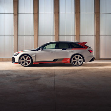 Car with a red and grey livery parked in front of frosted glass panels.