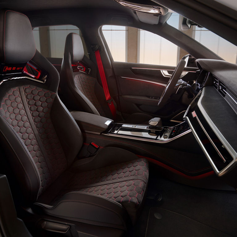 Car interior with high-end finishes and red accents on seats and doors.