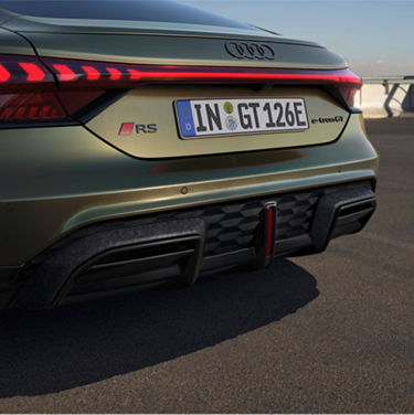 Rear view of an Audi RS e-tron GT Performance with European license plate, on a road at dusk.