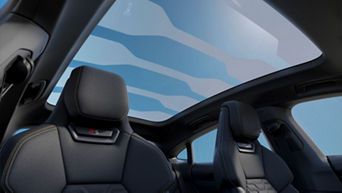 Interior view of a car showing two black seats with a large panoramic sunroof.