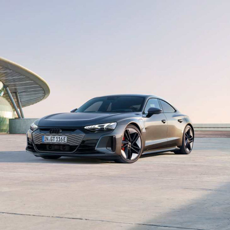 Audi RS e-tron GT parked on a concrete rooftop at dusk.