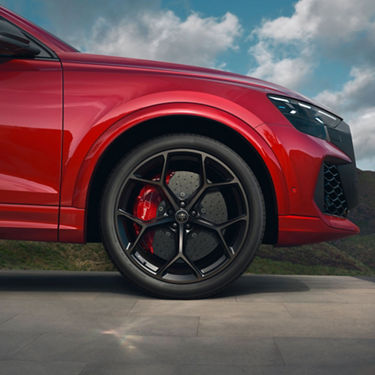 Red Audi Q8 RS Performance side view of front section.