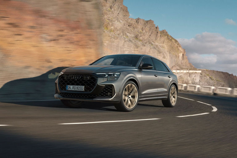Audi RS Q8 driving up a mountainside with a blurred background.