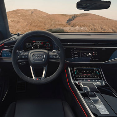 Driver seat view of steering wheel and touch screen panel and console display unit.
