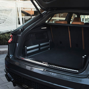 Audi RS Q8 with open boot in residential area.