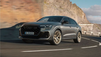 SUV driving on a coastal road with cliffs in the background.