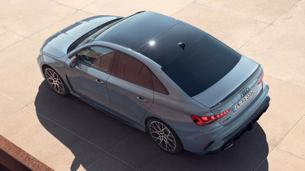 Aerial view of a gray Audi RS3 Saloon parked outdoors on concrete.