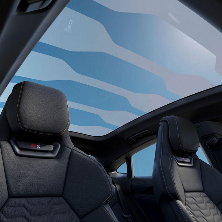 Interior view of a car with luxury seats and a large panoramic sunroof.