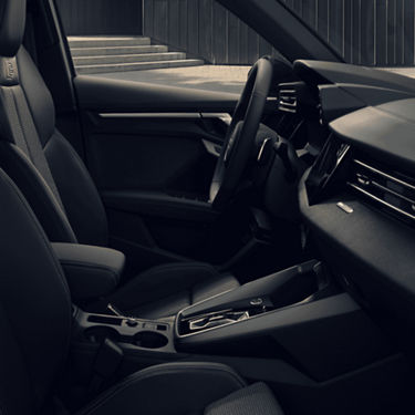 Interior of an Audi car showing steering wheel, dashboard, and seats.