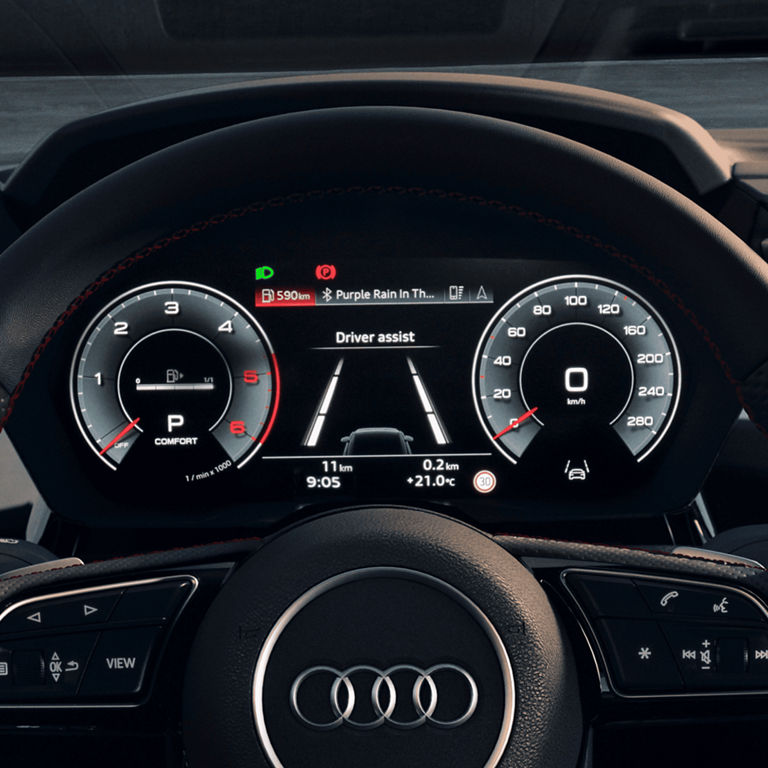 Audi car dashboard showing digital speedometer, fuel gauge, and driver assist system.