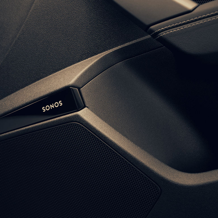 Close-up of a black Sonos speaker detail in a car door.