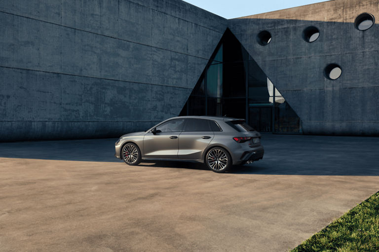 Audi S3 Sportback car parked near a modern building with circular windows.