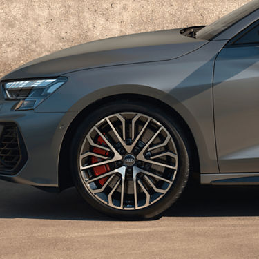  Close-up of a grey Audi S3 car's front wheel and headlight.