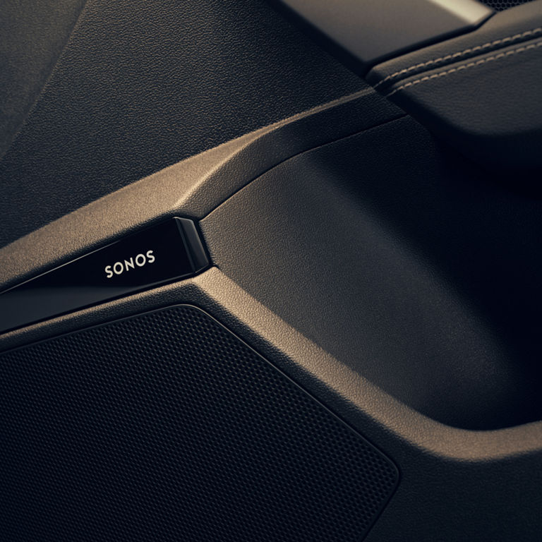  Close-up of a black Sonos speaker detail in a car door.