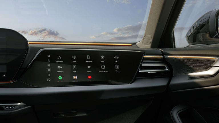 Car interior with infotainment touchscreen displaying icons such as navigation and radio.