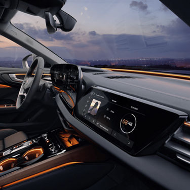 Car's interior at dusk with dashboard screens illuminated.