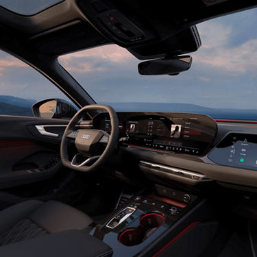 Interior of a car with a digital dashboard and central screen, steering wheel with logo visible. 
