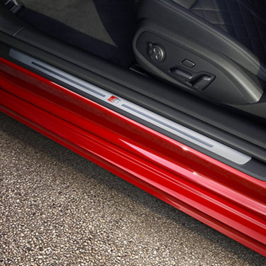 Car door threshold with a protective sill plate and illuminated logo.