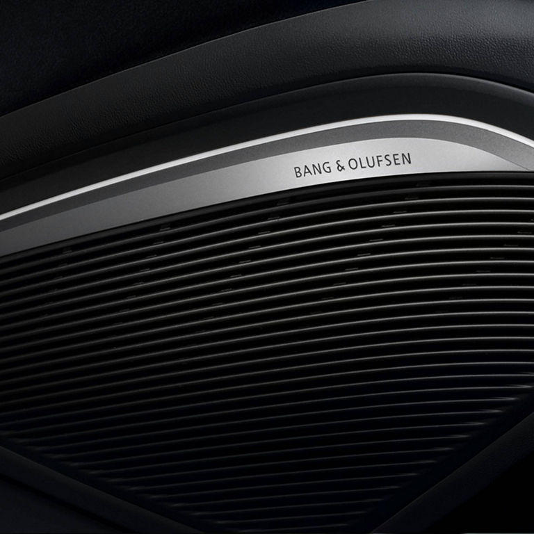 Close-up of a Bang & Olufsen speaker grill in a car interior.