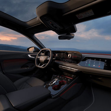 Interior view of an Audi car with modern dashboard and steering wheel at dusk.