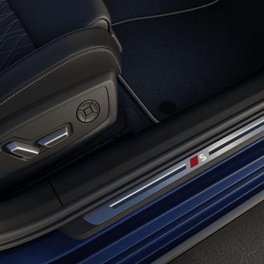 Close-up of a car's luxury interior detailing with an 'S' badge on the door sill.