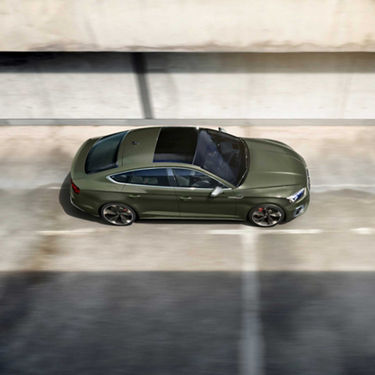 An olive green car driving on a road, viewed from an overhead perspective.