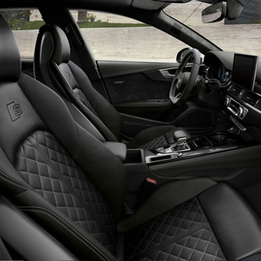 Car interior with leather seats, dashboard, and steering wheel.