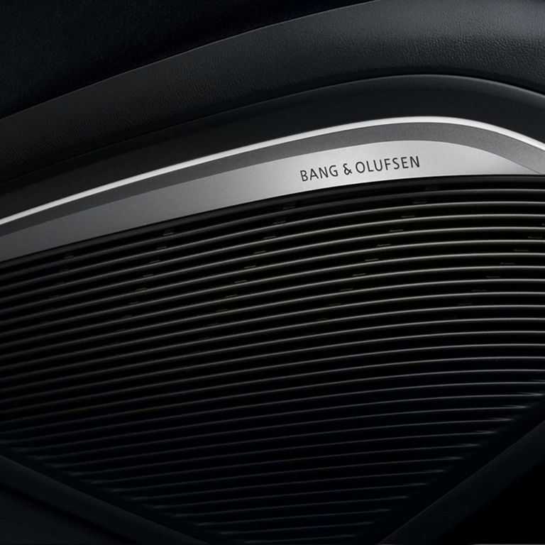 Close-up of Bang & Olufsen speaker grille in a car interior.