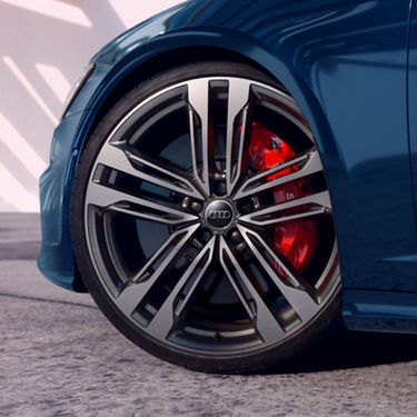 Close-up of an Audi car wheel with distinctive silver rims and red brake callipers.