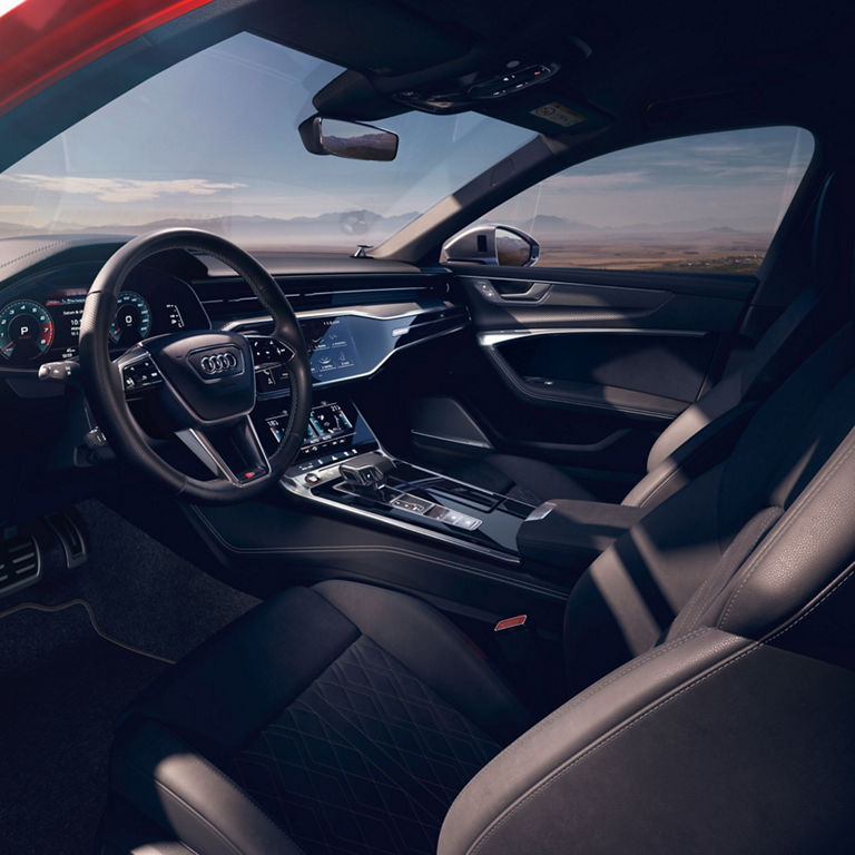 Interior view of a car showcasing the steering wheel, dashboard, and infotainment system.