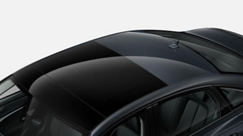 Close-up of a black car's roof with a shark fin antenna.