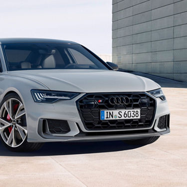 A silver Audi sedan parked with an urban backdrop.