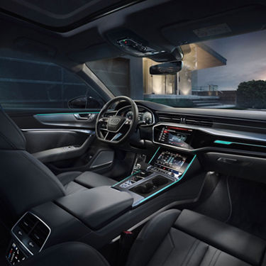 Interior view of a car with illuminated dashboard and touchscreen controls.