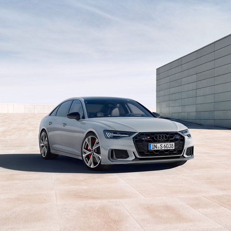 Silver sedan parked on a spacious, sleek concrete surface with a clear sky above.