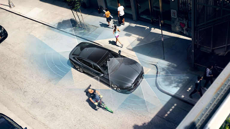 Aerial view of a black car with sensor waves illustrating parking assist technology, surrounded by pedestrians.