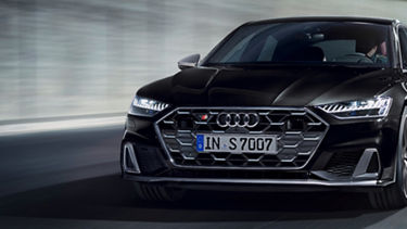 Black Audi car in motion on a blurred background.