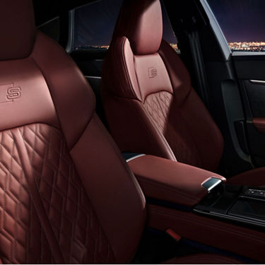 Car interior with red leather seats and diamond stitching.