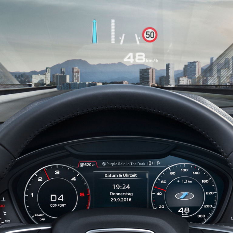 Driver's view of a car dashboard with a head-up display showing speed and navigation, city skyline ahead.