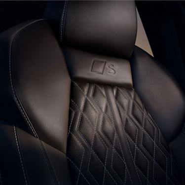 Car seat with embroidered logo and intricate stitching design.