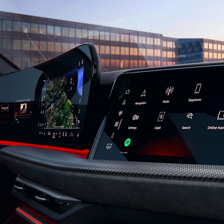 Car interior with a large touchscreen displaying icons like navigation, radio, and YouTube.