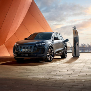 Electric car charging at a station with a city skyline in the background.
