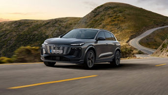 A SUV driving along a winding road with mountains in the background.