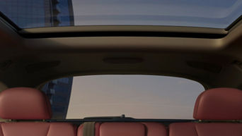 Interior view of a car with red seats and an open panoramic sunroof.