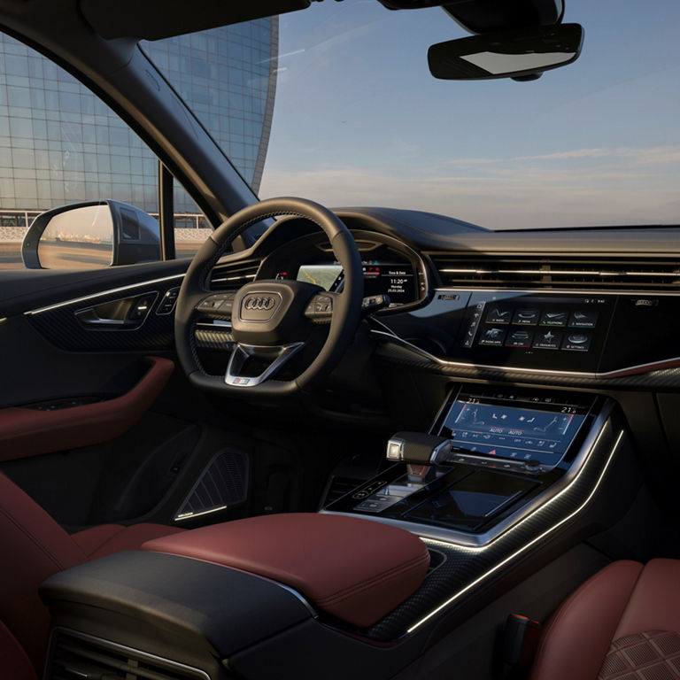 Interior view of a car with a focus on the steering wheel, dashboard, and infotainment system.