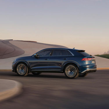  Side view of Audi SQ8 in motion on bending road.