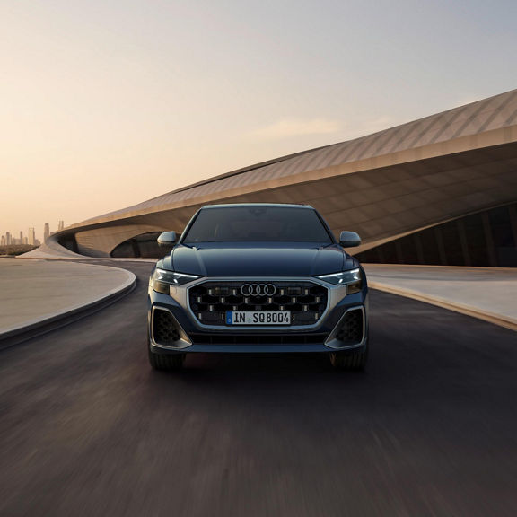 Front view of Audi SQ8 driving on isolated road.